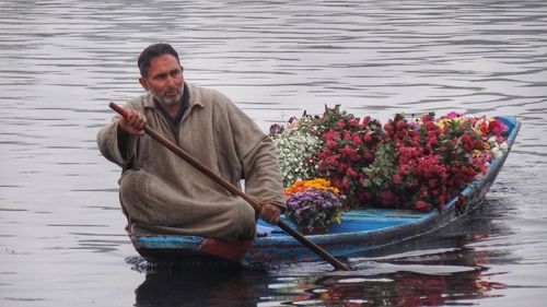 Man holding flowers in lake