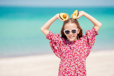 Portrait of woman with sunglasses standing on beach