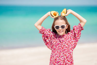 Portrait of woman with sunglasses standing on beach