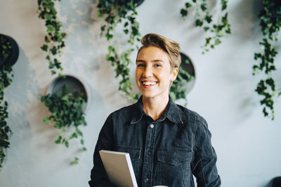 Portrait of smiling businesswoman with diary in office