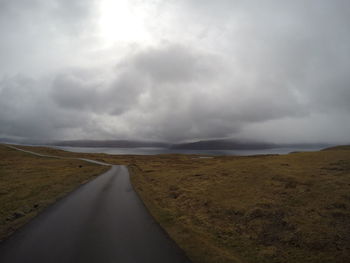 Empty road against cloudy sky