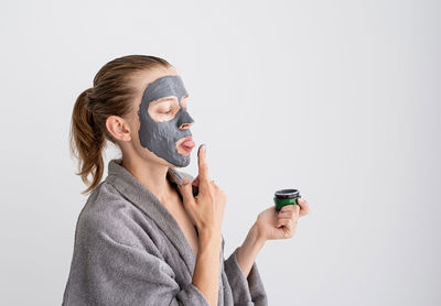 Womens health. spa and wellness. happy funny woman applying face mask and tasting it