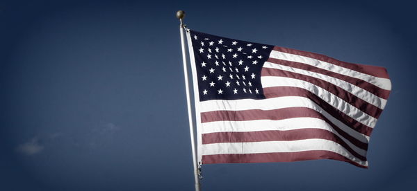 Low angle view of american flag against sky