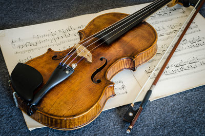High angle view of violin and sheet music on table