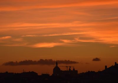 Silhouette buildings against sky during sunset