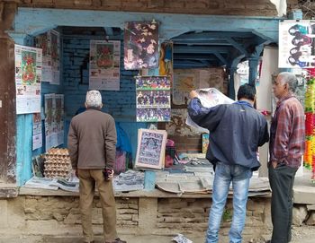 Rear view of people standing against wall