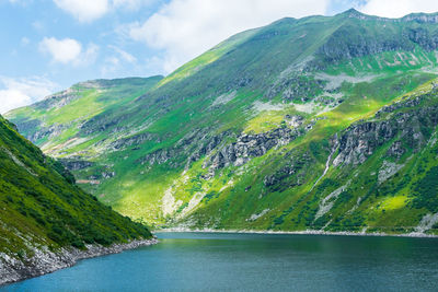 Scenic view of river amidst mountains against sky