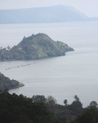 Scenic view of sea and mountains against sky