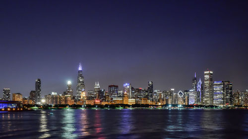 Illuminated buildings against sky at night