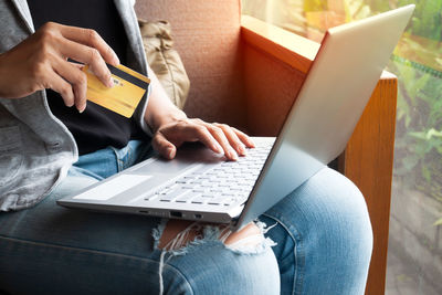 Midsection of woman using mobile phone