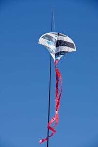 Low angle view of flags against clear blue sky