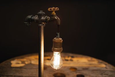 Close-up of illuminated electric bulb on tap