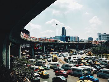 Railway bridge and city traffic against sky