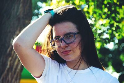 Close-up portrait of young woman with hand in hair