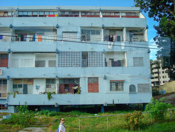 Woman outside house against sky