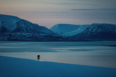 Man skiing with headlamp in iceland at sunrise