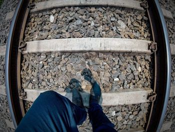 Low section of man standing on railroad track