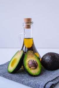 Pitcher of natural oil and fresh ripe hass avocados. preparing food in the kitchen. ingredients. 