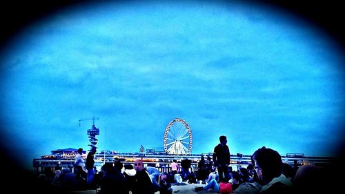 People in amusement park against sky