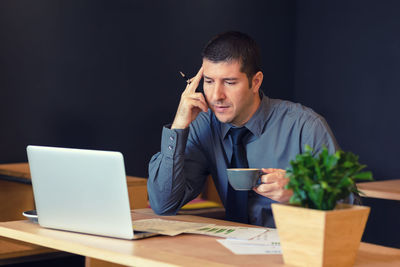 Man using mobile phone while sitting on table