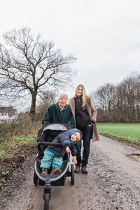 Portrait of family standing on dirt road during winter