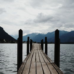 Wooden pier over lake against sky