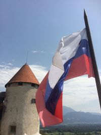 Bled castle and slovakian flag against sky