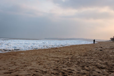 Man standing on beach against sky