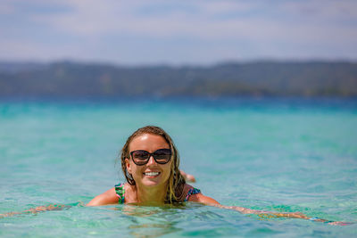 A young, beautiful girl in sunglasses swims in the sea. high quality photo