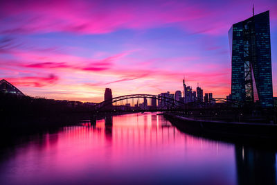 Silhouette of bridge over river against cloudy sky