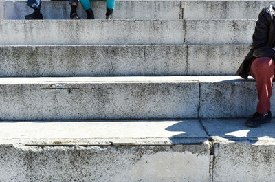 Low section of people sitting on concrete steps