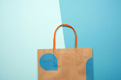 Directly above shot of paper bag over blue background