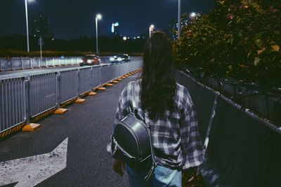 Rear view of woman on street at night