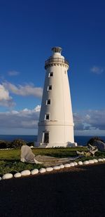 Lighthouse on landscape against sky