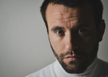 Close-up portrait of young man against white background