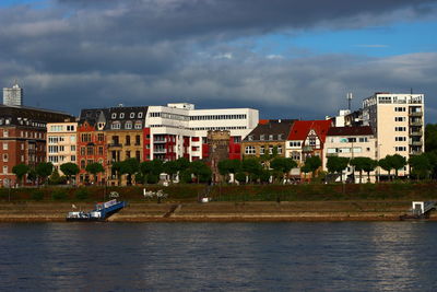 River by buildings against sky in city