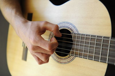 Midsection of man playing guitar