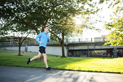 Full length of man jogging on footpath at park