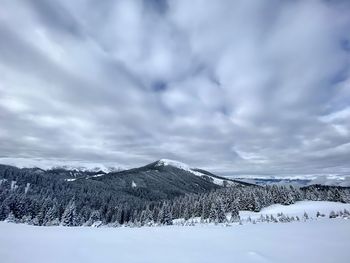 Snow covered landscape against sky