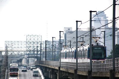 Train on railroad track by road against clear sky