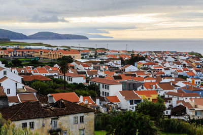 High angle view of townscape by sea against sky