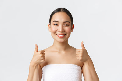 Portrait of smiling young woman against white background