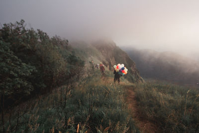 People walking on mountain against sky