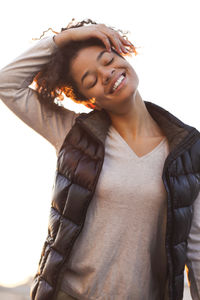 Portrait of young woman standing against white background