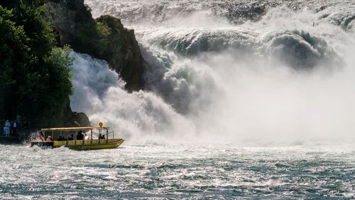 Ferry boat by waterfall in river