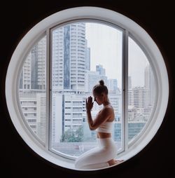 Young woman exercising on window at home