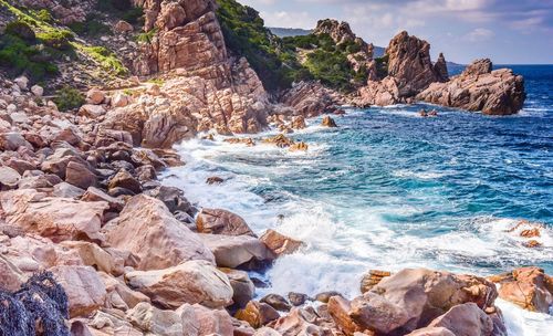 Rock formation in sea against sky