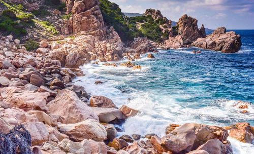 Rock formation in sea against sky