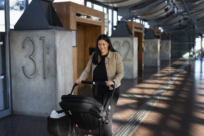 View of woman pushing pram at train station