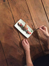 Cropped image of chef preparing dessert in plate on table